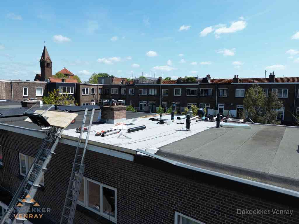 Dakdekkers aan het werk op plat dak in Venray